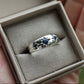 Silver ring with embedded stones in a jewelry box