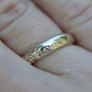 Silver ring with intricate design on a finger