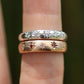 Two diamond-studded rings on a finger with a blurred background